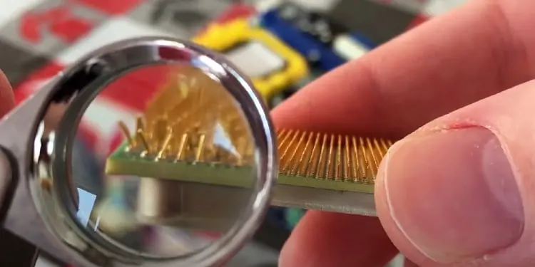 RAM Slot Not Working on My Motherboard - How to Fix it? 7 Checking-cpu-bent-pins-with-a-magnifying-glass