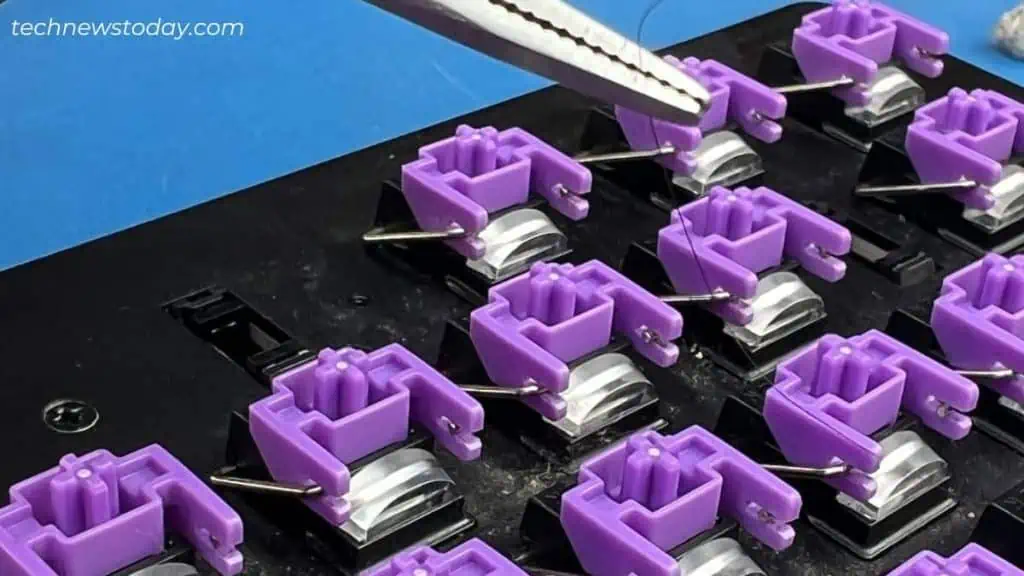 How to Clean Mechanical Keyboard in 7 Steps 9 pulling-hair-strand-using-tweezers-from-razer-keyboard-1024x576